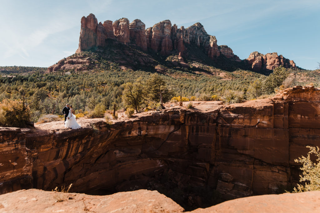 A couple stands together at the edge of the Devil's Kitchen sinkhole in Sedona Arizona.