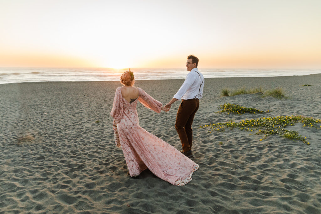 A redwoods elopement couple standing on a beach along the california coast.