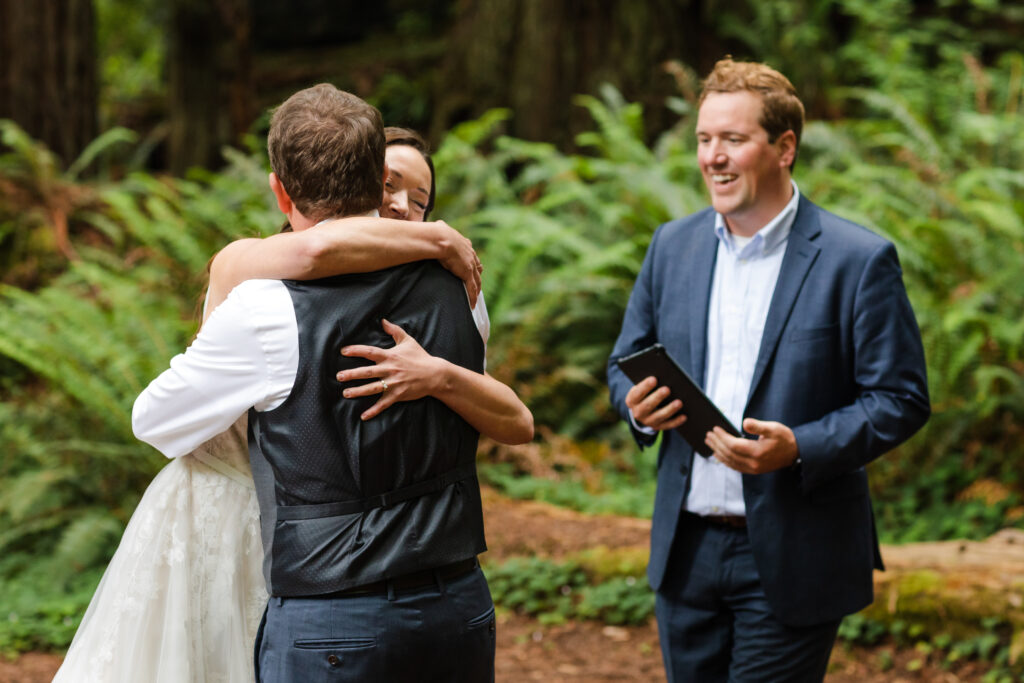 A bride and groom embrace in a hug during their redwoods elopement ceremony